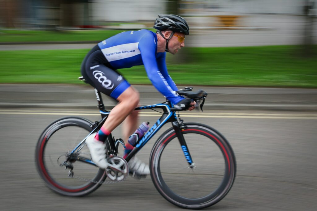 Rennradfahrer mit blauem Trikot und Helm fährt auf seinem Rennrad