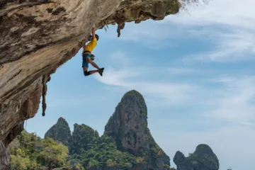 Person klettert an Felsen hoch