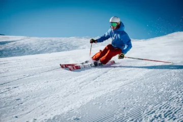 Person fährt mit Skiern Piste runter