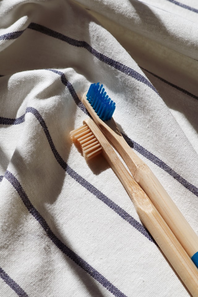 Zwei Zahnbürsten aus Holz liegen auf einem Geschirrhandtuch